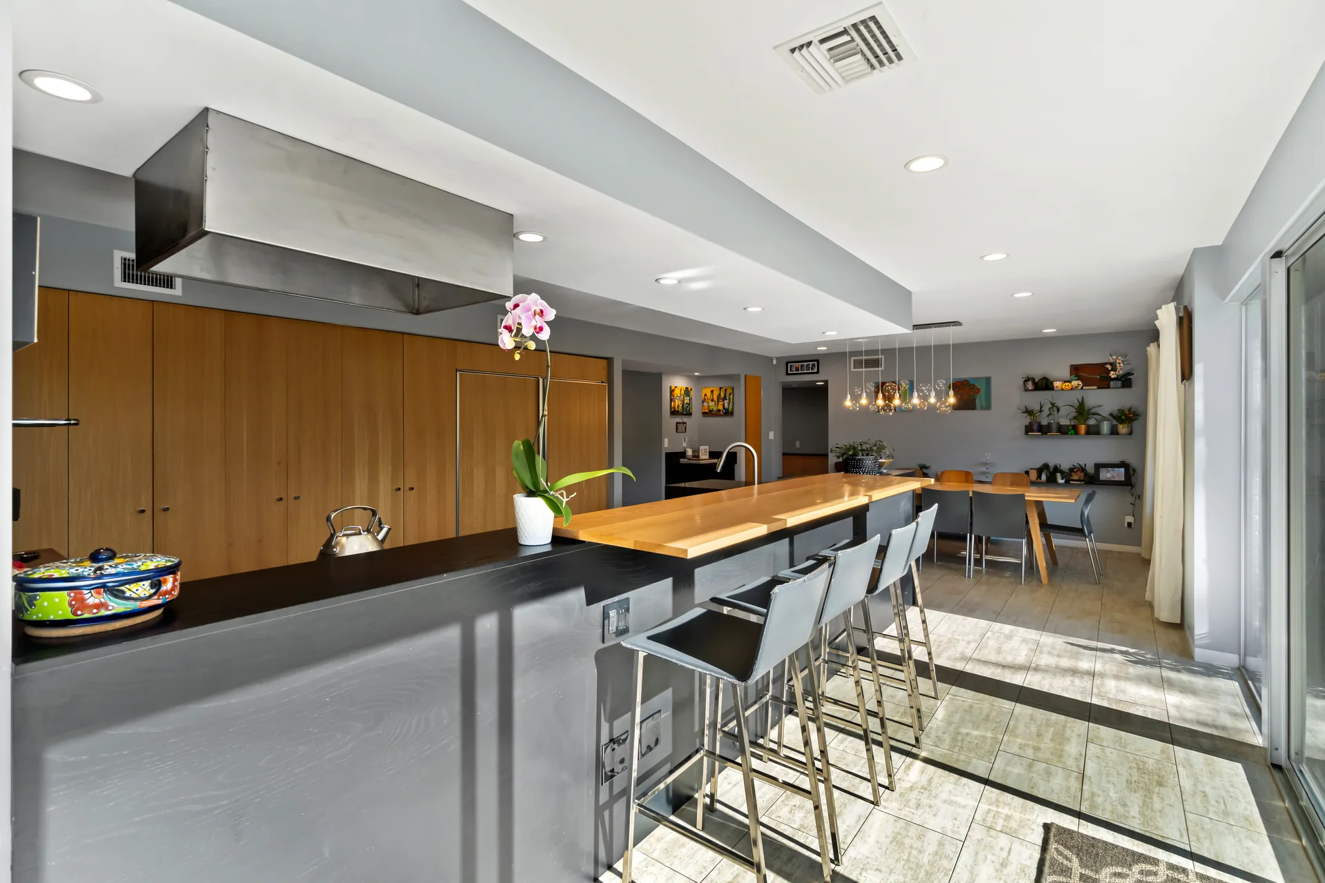 A residential kitchen with full-height wood cabinetry and a waterfall island counter