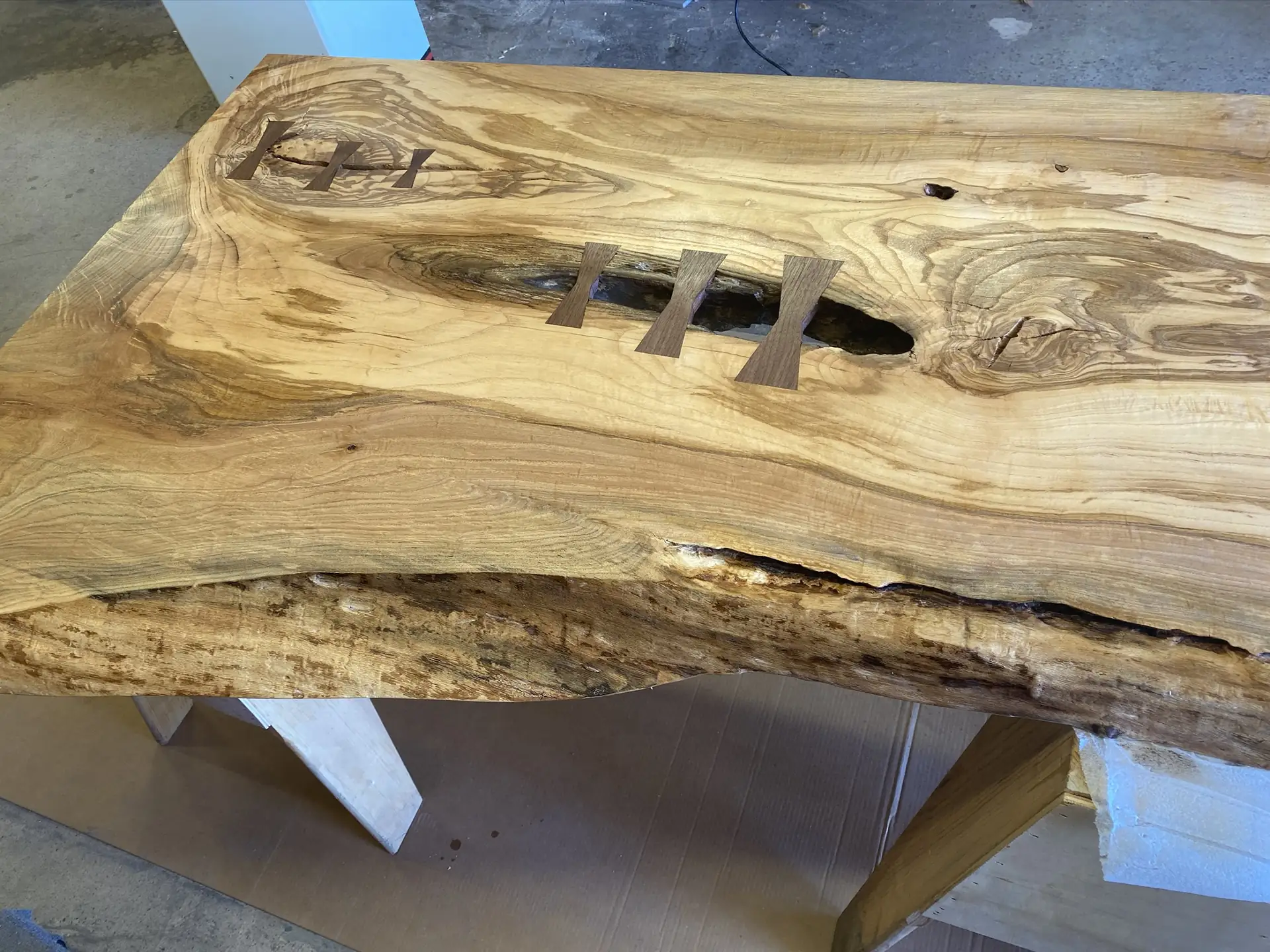 A live-edge slab top with contrasting butterfly keys set across a natural void