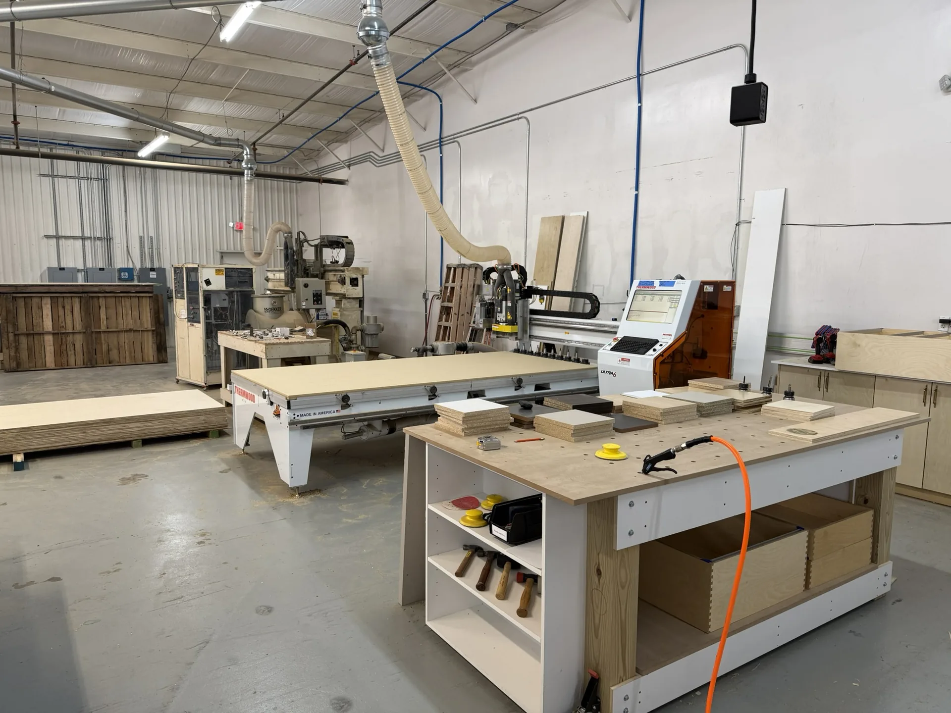 The shop floor looking across the assembly bench to the CNC router and edgebander