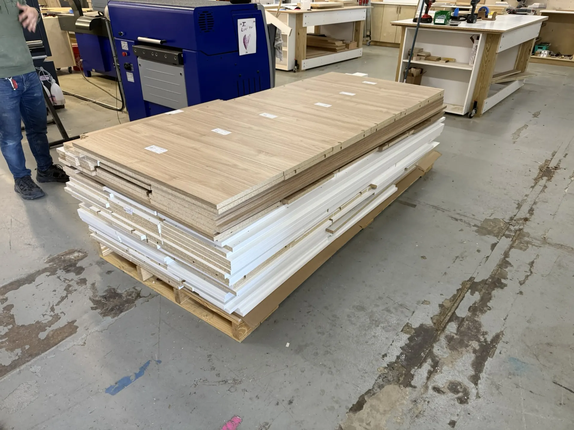 A pallet of finished panels — white melamine and prefinished plywood — banded and ready for pickup