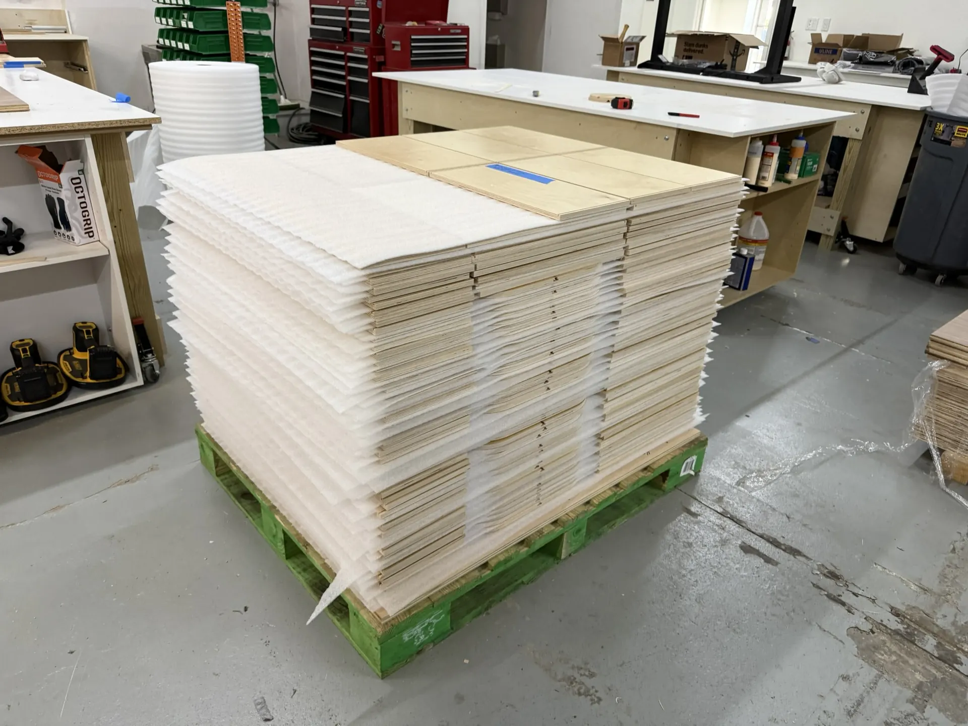 A pallet stacked shoulder-high with cut and edgebanded panels, labeled for a single job
