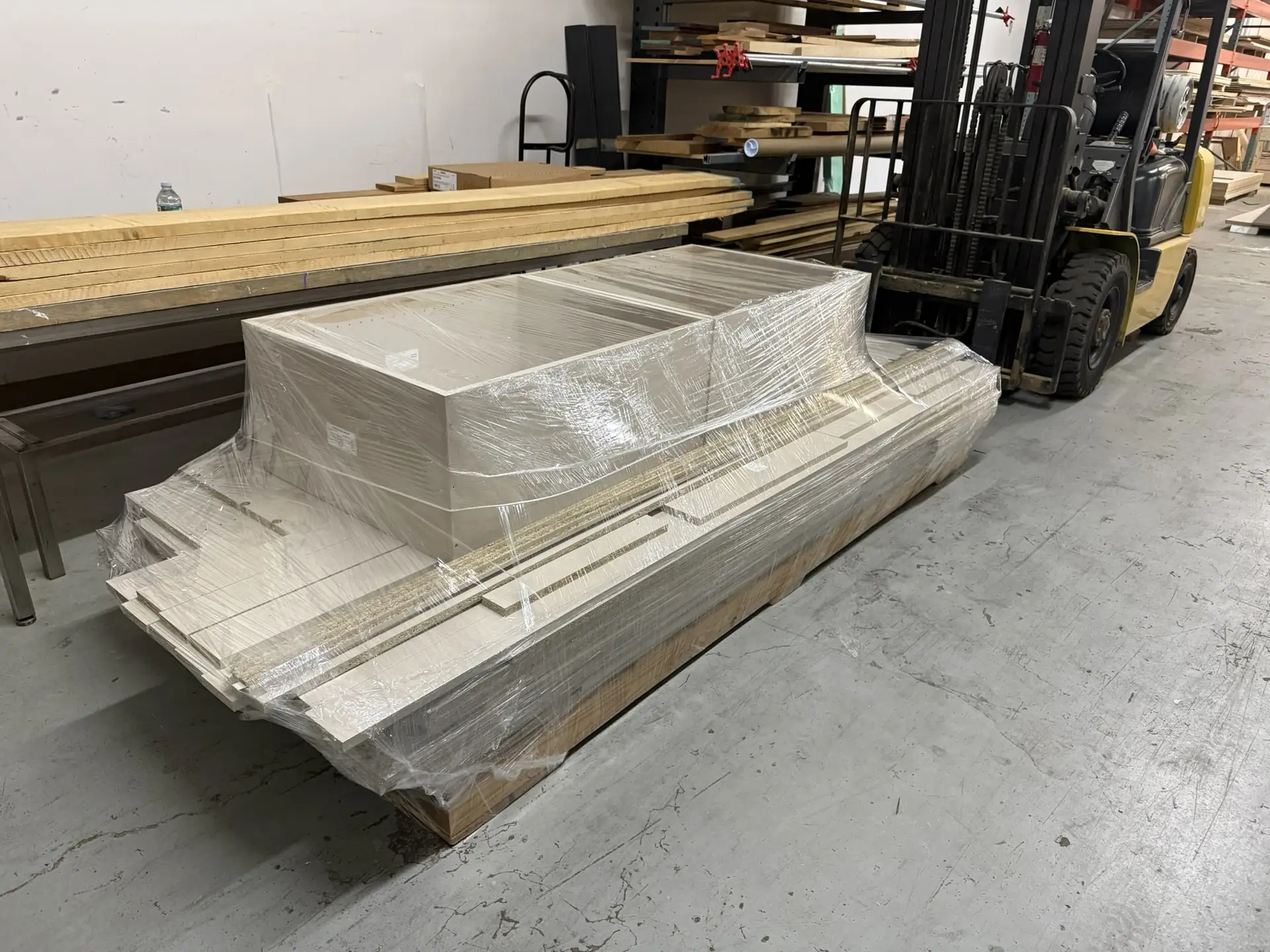 A shrink-wrapped pallet of finished parts staged for the forklift
