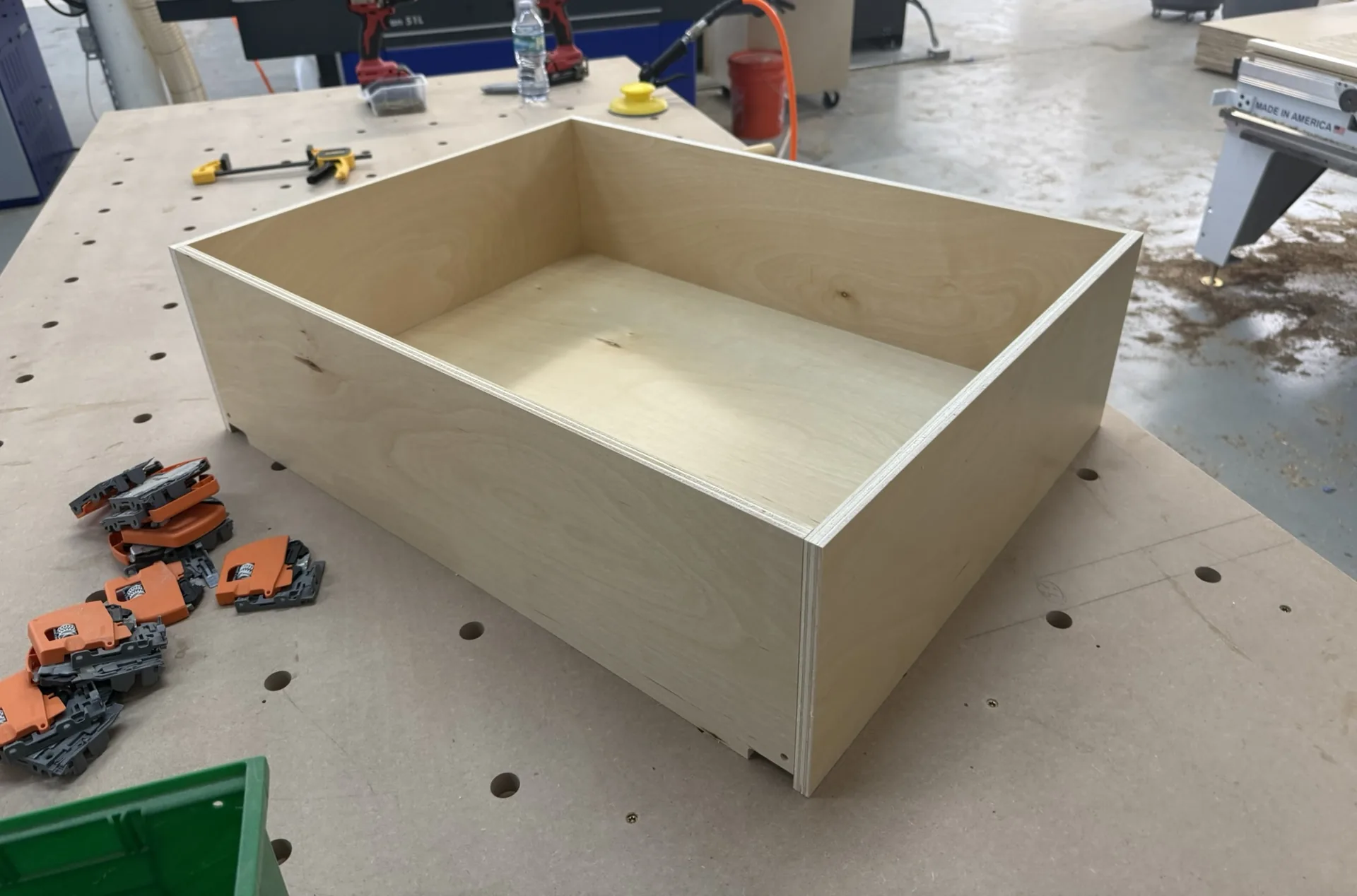 An assembled birch plywood drawer box squared up on the assembly table