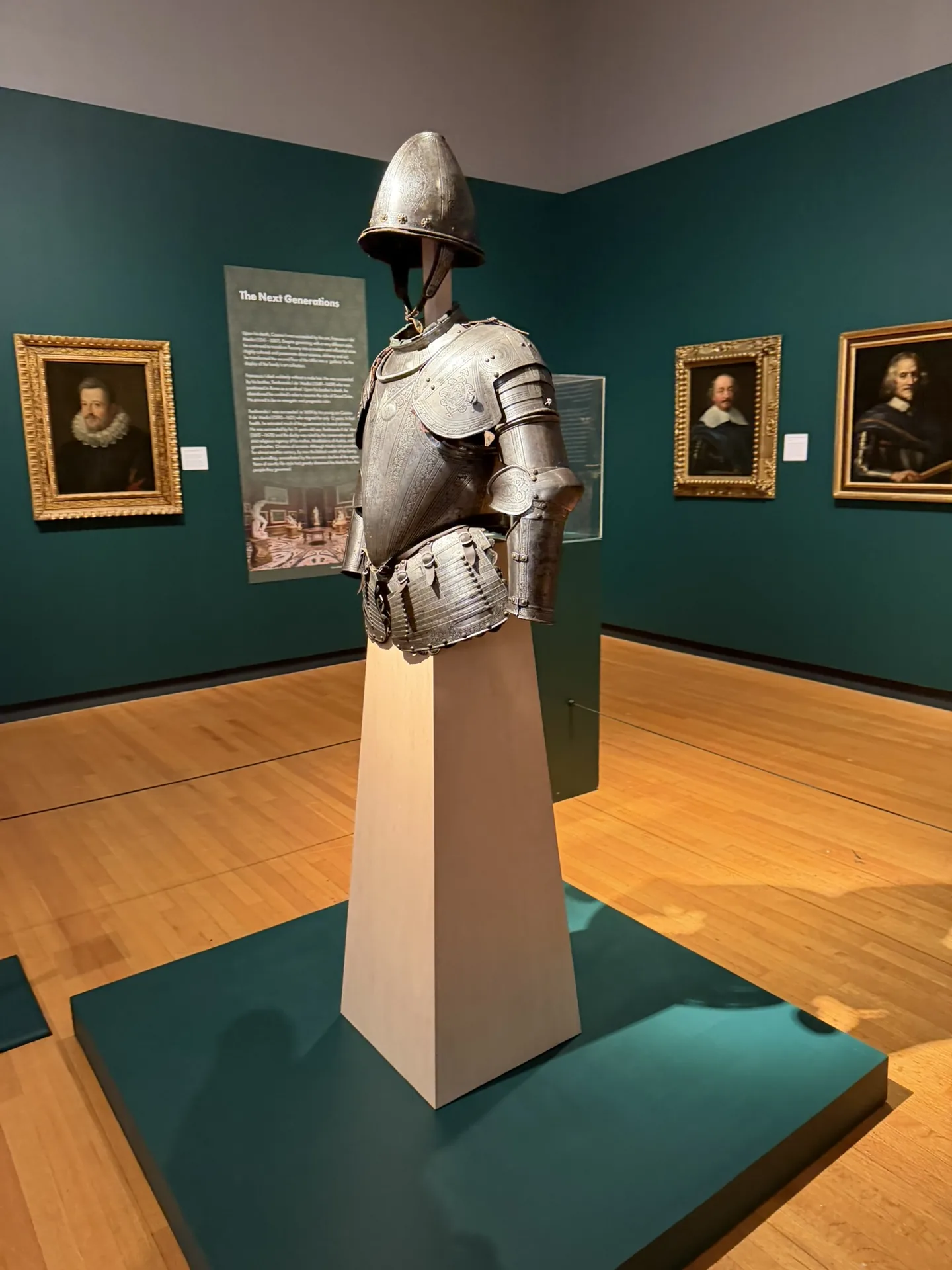 A tapered plinth supporting a suit of armor on a raised gallery platform