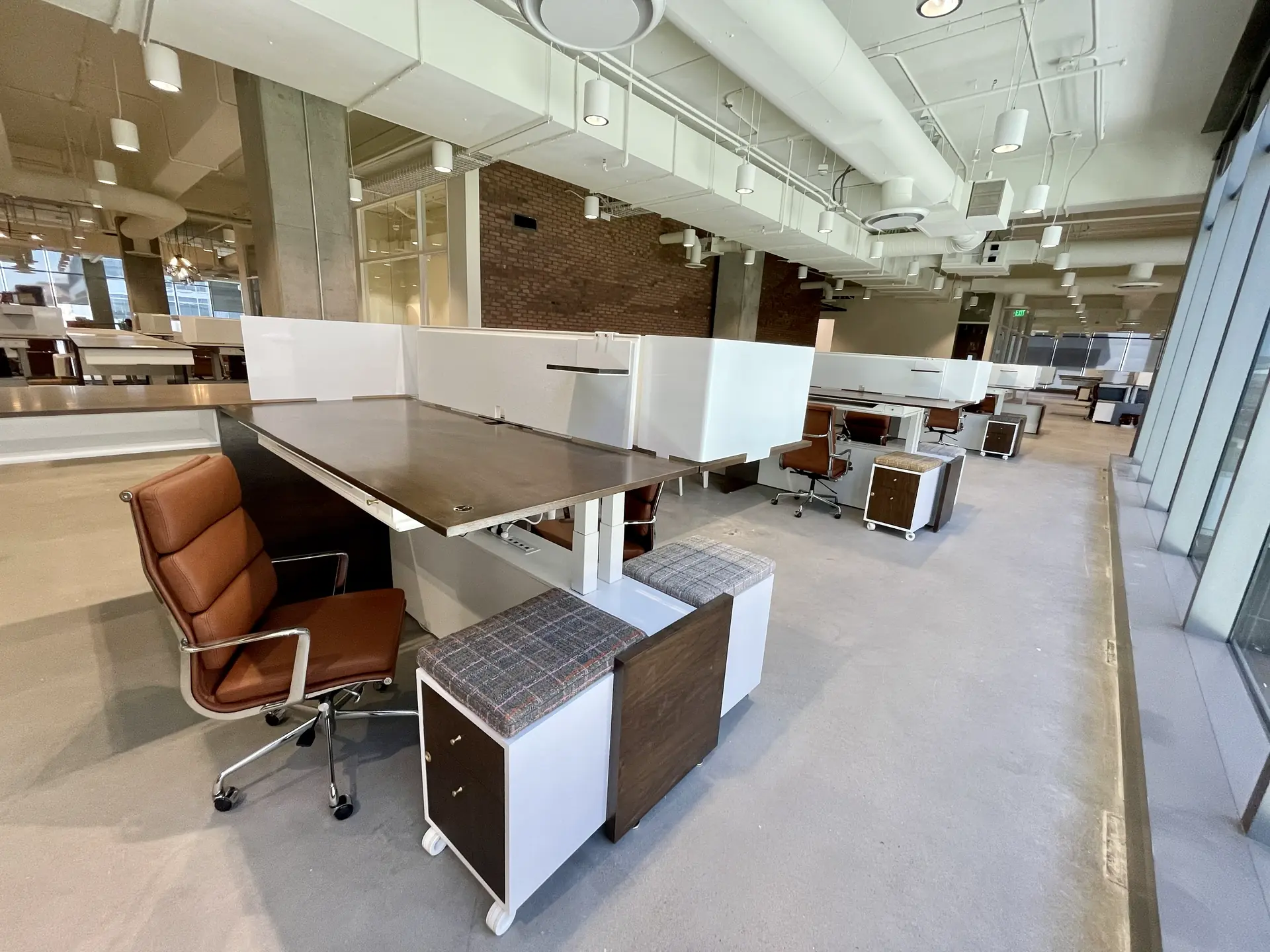 Open office desks with rolling storage pedestals topped with upholstered cushions